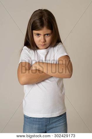 Pretty Little Girl With Angry Facial Expression Looking Mad At The Camera. Human Emotions