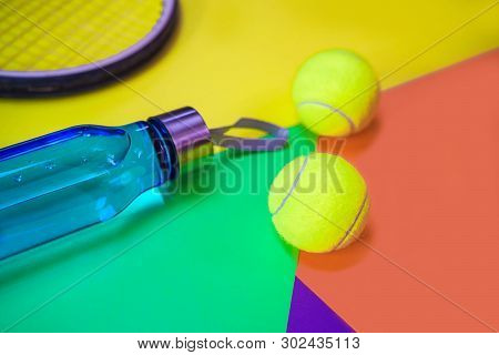 Tennis Layout With Tennis Balls, Racket, Bottle Of Water On Abstract Different Multicolored Neon Bac