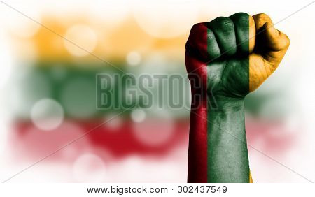 Flag Of Lithuania Painted On Male Fist, Strength, Power, Concept Of Conflict. On A Blurred Backgroun