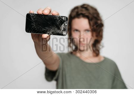 Curly Woman Need To Repair Her Broken Smartphone Afteraccident. Isolated On Graybackground.