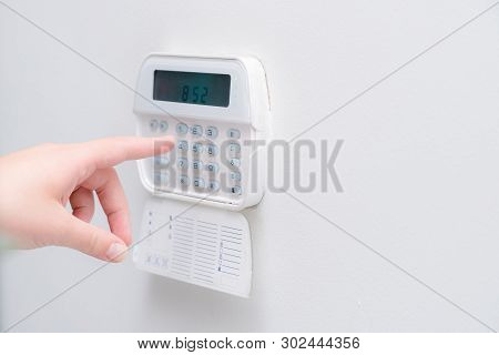 Woman Hand Entering Alarm System Password Of An Apartment, House Of Business Office. Surveillance An