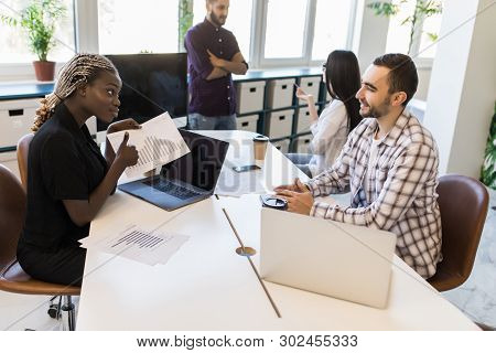 Group Of Business Mixed Race Partners Discussing Strategies At Meeting In Office