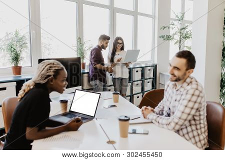 Group Of Business Mixed Race Partners Discussing Strategies At Meeting In Office