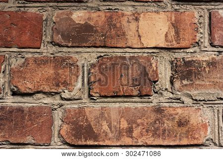 Brick Wall Fragment. Old Dirty Orange And Red Bricks With Defects. Grunge Texture With Cracks And We