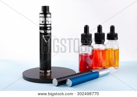 Electronic Cigarettes And Glass Bottles With Vape Liquid On White Background