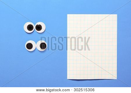 Two Pair Strabismus And Squint Mad Googly Eyes On Blue Paper Background With Copy Space For Text. Ma