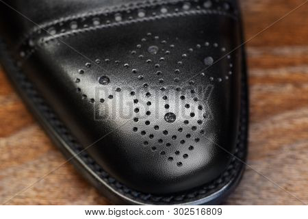 Black brogue toe of men full grain leather shoe, close up
