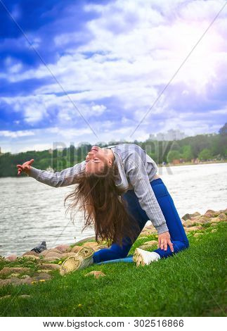Young Girl Goes In For Sports In Nature. Healthy Lifestyle.flaxible Child Doing Joga Poses Bridge St