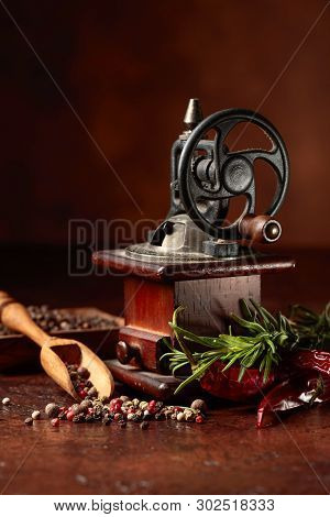 Vintage Pepper Mill With Various Peppers And Spices. Old Pepper Mill With Cooking Utensils, Spices A