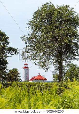 A Red Roofed Lighthouse Framed By Trees