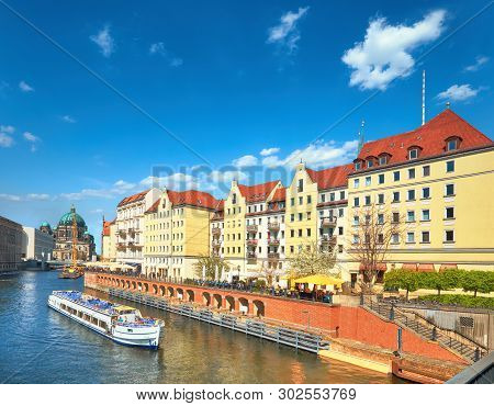 Riverside With Old Houses In East Center Of Berlin, Germany, On A Bright Day With Blue Sky