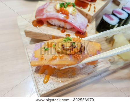 Chopstick Hold On The Makuro With Sauce Sushi Or Nigiri With Maki In The Frame