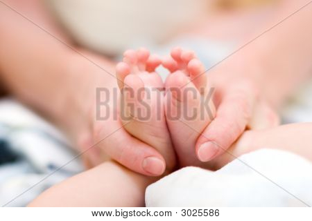 Matka jemně masírovat nohy dítěte