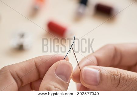 People, Needlework, Sewing And Tailoring Concept - Tailor Woman With Thread In Needle Stitching Fabr
