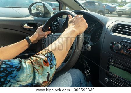 Female Hands Lie On The Steering Wheel Of A Car.