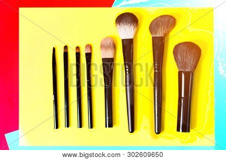Various Makeup Brushes On A Bright Yellow Background, Close-up,