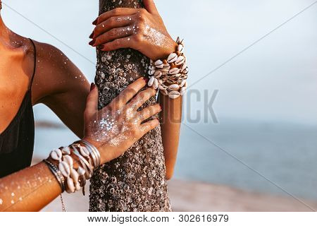 Close Up Of Young Woman Hands Wearing Boho Accessories Made Of Cowry Shells
