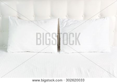 Soft White Quilted Pillow In Bed On The Background Of White Leather Quilted Headboard. Clean Pillow,
