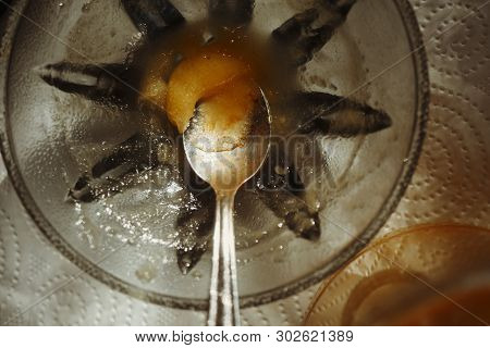 Overhead Macro Shot Of A Silverspoon Left In A Saucer With Jam Or Honey