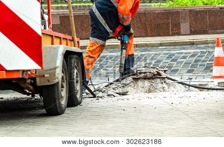 Male Worker With Full Safety Equipments Drilling And Repairing Concrete Driveway Surface With Jackha
