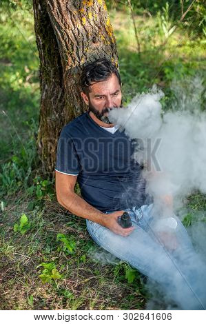 Confident Man Releases A Cloud Of Steam. Electronic Cigarette Concept.