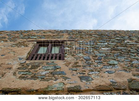 Wooden Window On A Stone Wall Of The Historic Muttrah Fort In Muscat, Oman. Low Angle View.