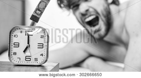 Annoying Ringing Alarm Clock. Man Bearded Annoyed Sleepy Face Lay Pillow Near Alarm Clock. Guy Knock