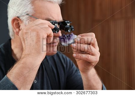 Male Jeweler Evaluating Semi Precious Gemstone In Workshop, Closeup