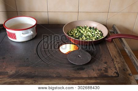 Zucchini In A Pan Are Cooked Over A Stove In A Mountain Hut