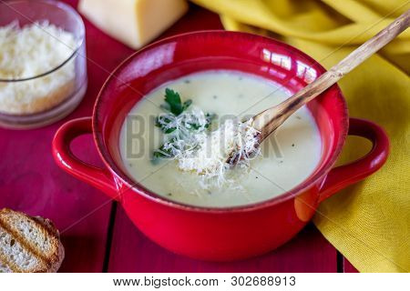 Cheese Cream Soup On A Red Wooden Background. White Bread Croutons. Ingredients.