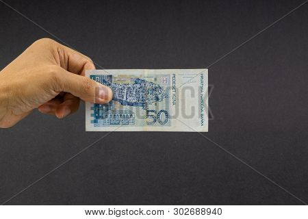 Hand Holding Fifty Croatian Kuna Or Sto Kuna Bank Notes On Black Background. Financial Concept And S