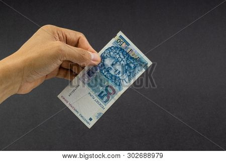 Hand Holding Fifty Croatian Kuna Or Sto Kuna Bank Notes On Black Background. Financial Concept And S