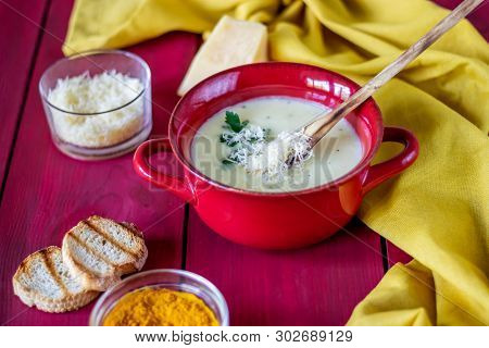 Cheese Cream Soup On A Red Wooden Background. White Bread Croutons. Ingredients.