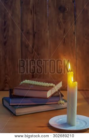 The Holy Quran And Lights. Muslims Holy Book Koran. The Holy Quran With Praying Beads On Wooden Back