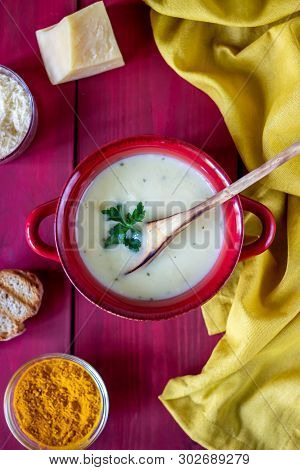 Cheese Cream Soup On A Red Wooden Background. White Bread Croutons. Ingredients.