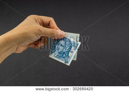 Hand Holding Fifty Croatian Kuna Or Sto Kuna Bank Notes On Black Background. Financial Concept And S