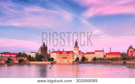 Prague, Riverside On Sunset, With Charles Bridge On The Right And Historic Skyline Of Novotnevo Lavk