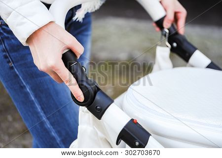 Woman Strolling With White Baby-carriage. Close Up Of Female Hands Push The Button To Change Positio