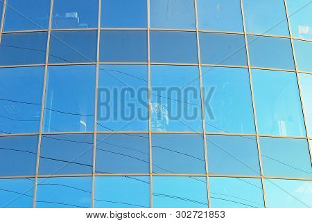 New Office Building In Business Center. Wall Made Of Steel And Glass With Blue Sky.