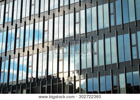 New Office Building In Business Center. Wall Made Of Steel And Glass With Blue Sky.