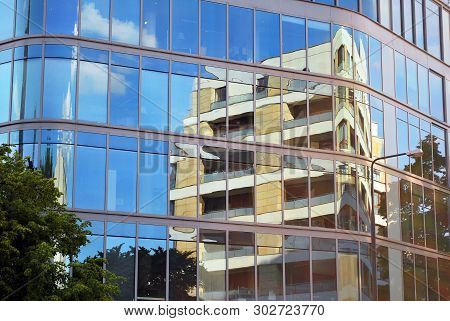 New Office Building In Business Center. Wall Made Of Steel And Glass With Blue Sky.