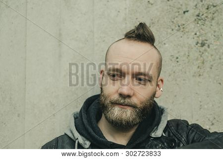 Thinking Bearded Man Looking Down In Front Of A Wall