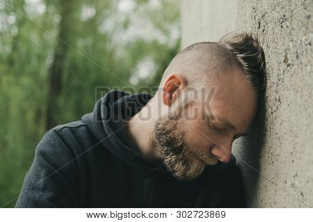 Depressed And Lonely Man His Head Against A Wall