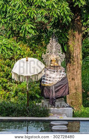 Bedugul, Bali, Indonesia - February 25, 2019: Hindu Shrine Behind Pond In Green Garden Along Road Se