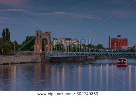 Grunwaldzki Bridge in Wroclaw, Poland with reflection in Odra River. Beautiful Sunset in city skyline, Breslau, 2019.