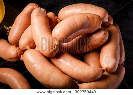 Closeup Heap Of Raw Short Thick Wieners Rolled In Spiral On Scales