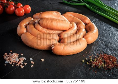 Circle Set Of Uncooked Short Sausages On Black Background