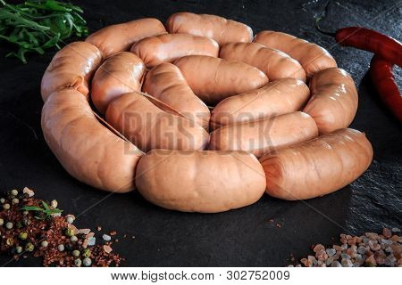 Closeup Circle Of Raw Short Sausages With Salt, Rucola And Chili