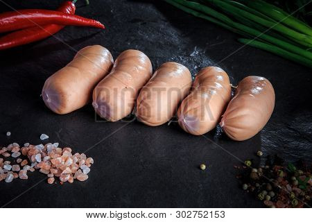 Closeup Row Of Five Short Thick Sausages With Chili And Onion