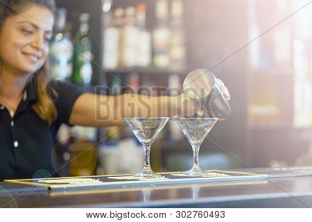 Bartender Woman Pours A Fresh Cocktail To The Customers Of The Hotel Bar. The Bartender Girl Pours A